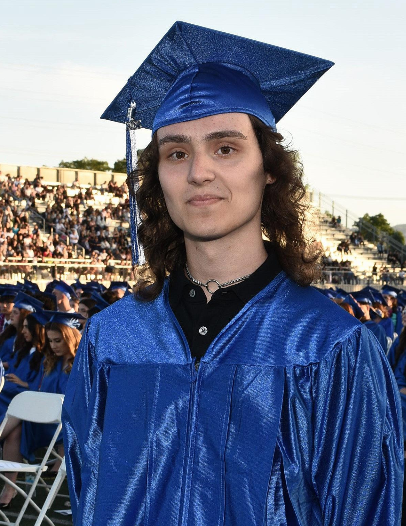 Ash in a blue graduation cap and gown